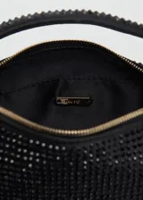 Bolso de mano tipo baguette, color negro, cubierto de pedrería brillante. Presenta un diseño estructurado con asa corta integrada y cierre superior.