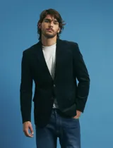 Saco sport de pana color marrón, con cuello de solapa, cierre frontal de dos botones, bolsillos laterales con tapa y puños con botones.