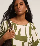 Vestido corto de viscosa con estampado de hojas y cuello redondo. Modelo t-shirt de mangas cortas.