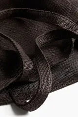 Bolso de playa color marrón, tipo tote, confeccionado en tejido texturizado con dos asas superiores.