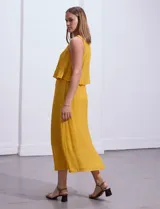 Vestido largo blanco de crepe con escote redondo y detalle de crochet en los hombros. Tiene corte en la cintura con punto smock.