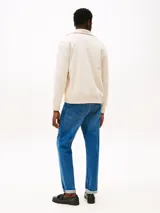 Buzo con cierre de cremallera, confeccionado en felpa de algodón color crema. Cuenta con cuello chimenea, dos bolsillos delanteros tipo canguro, puños y bajo de punto canalé. Incluye logo de Tommy Hilfiger bordado en el pecho.