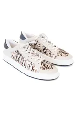 Championes urbanos con diseño de paneles combinados en cuero liso color crema y piel con estampado animal print. Presentan detalle de talón en cuero negro, cordones al tono y suela de goma blanca.