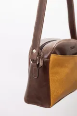 Bandolera semirrígida Sagali de cuero vacuno color bordó, con textura de cocodrilo en el bolsillo frontal y cuerpo liso. Cuenta con cierre superior y correa regulable.