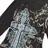 Remera negra de manga larga, corte ajustado (slim fit), con escote en V y estampado frontal grande de una cruz ornamentada con detalles en gris y blanco.