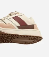 Championes urbanos Satinato, color beige con detalles en marrón, bordó, rosado y verde. Cuentan con capellada de poliuretano con recortes, cierre de cordones y suela plana estructurada.