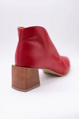 Botines de cuero color beige con diseño de tajo frontal, punta fina y taco cuadrado de madera.