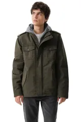 Campera de estilo militar en color verde oliva, confeccionada en algodón resistente. Presenta un diseño con capucha gris integrada, cierre frontal con cremallera y solapa con botones a presión, además de bolsillos frontales con solapa y charreteras en los hombros.