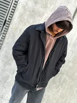 Campera negra con cierre frontal, cuello camisero y bolsillos laterales.