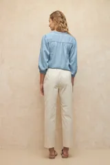 Pantalón color beige de algodón, tipo paper touch, con elástico en la cintura y cordones. Tiene un fit recto con bolsillos de solapa y botones a tono.