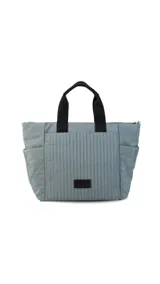 Cartera tipo tote de nylon color malva, con diseño capitoneado de líneas verticales en el frente y rombos en los laterales. Cuenta con doble asa de mano en color negro, bolsillos laterales y un parche decorativo con logo en la parte frontal.