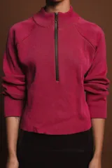 Sweater fucsia de punto con cuello alto y cierre de cremallera metálica.
