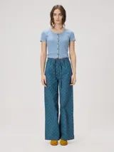 Pantalón de pierna recta tiro alto, con estampa geométrica color azul. Cuenta con cintura elastizada, cordón de ajuste y detalles de vivos en rojo en la cintura y costuras laterales.