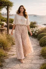 Pantalon palazzo de corte amplio y fluido, confeccionado en tela plisada con estampado estilo paisley en tonos beige y rosado. Presenta cintura elastizada y un diseño ligero ideal para climas cálidos.