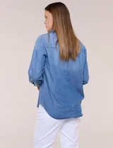Camisa confeccionada en tela tencel azul, de estilo casual y silueta semi holgada. Presenta cuello camisero tradicional, abotonadura frontal completa, dos bolsillos superiores en el pecho y mangas largas con presilla y botón para arremangar.