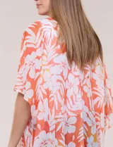 Kimono de diseño abierto, confeccionado en tela ligera con estampado floral en tonos anaranjados y blancos, de mangas amplias y corte holgado.
