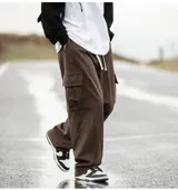 Pantalón cargo de pana marrón, de corte ancho y holgado, con cordón ajustable en la cintura y bolsillos cargo laterales.