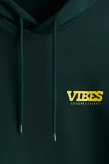 Canguro verde oscuro de peso medio con interior cepillado suave. Tiene bolsillo canguro, capucha de doble capa con cordón de ajuste y frente cruzado. Puños y bajo acanalados. Corte estándar. Estampado frontal con la palabra "VIBES" en amarillo.