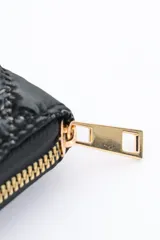 Billetera larga color lila con diseño acolchado y cierre perimetral con cremallera dorada.