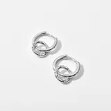 Par de aros plateados tipo argolla con un dije circular entrelazado decorado con strass. Cierre a presión.