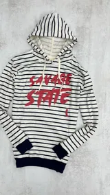 Canguro rústico a rayas horizontales blancas y negras, con capucha y cordones blancos. Estampado frontal con la frase "Savage State" en rojo.