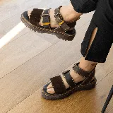 Sandalia de estilo chunky color negro, con suela track dentada y tres tiras ajustables con hebillas metálicas.