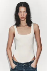 Body de tejido elástico color beige, con escote cuadrado y tirantes anchos.