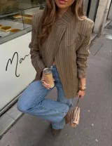 Blazer de corte relajado con diseño cuadrillé en tonos beige y marrón. Presenta hombros levemente estructurados, cierre cruzado con un botón y solapas clásicas.
