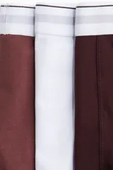 Pack de tres calzoncillos tipo trunk en color borgoña, blanco y marrón, con cintura elástica blanca con rayas horizontales. Confeccionados con tecnología Lycra® Xtra Life™.