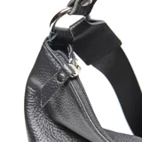 Mochila de cuero negro con textura granulada, diseño versátil con manija superior para llevar al hombro y cierre frontal vertical con cremallera. Incluye placa metálica con logo de la marca.