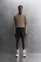 Short deportivo negro con estampado abstracto, cintura elástica ajustable con cordón, bolsillos laterales y trasero con cierre, forro interior y detalle de perforaciones en el ruedo.