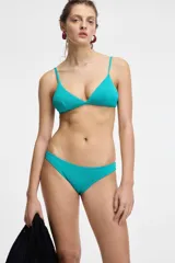 Bikini color turquesa con textura, compuesto por un corpiño triangular de tirantes finos y una bombacha de tiro bajo.
