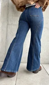 Jean de tiro alto con corte semi oxford, confeccionado en denim con elasticidad. Presenta un diseño con costuras verticales decorativas en el frente que estilizan la silueta.