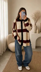 Saco de punto oversize con diseño geométrico de cuadros en tonos beige, marrón y bordó. Presenta cuello tipo polo, cierre frontal con botones negros y mangas largas con puños en contraste.