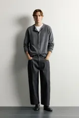 Jeans tapered wide fit de hombre, confeccionados en denim de algodón con efecto lavado en tono azul oscuro. Presentan diseño de cinco bolsillos, tiro medio, corte relajado y cierre frontal con cremallera y botón.