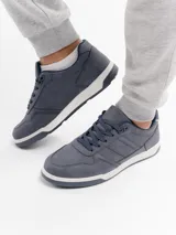 Championes urbanos de estilo casual, confeccionados en cuero sintético color azul, con cordones al tono y suela de goma blanca con base gris.