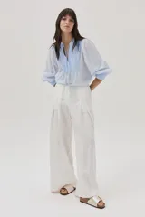 Blusa celeste a rayas verticales blancas, con cuello mao con lazos, mangas abullonadas y corte imperio.