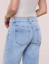 Jean wide leg de tiro medio, marca DJEANS, en tono azul claro con efecto acid wash. Presenta pretina con pasadores, cierre y botón, bolsillos delanteros inclinados y bolsillos traseros aplicados.