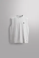 Camiseta sin mangas gris de corte regular fit, con cuello redondo. Presenta un bordado de un guante de boxeo en el pecho y un parche con logo en la parte inferior.