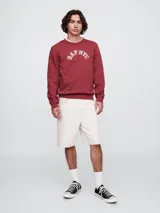 Buzo deportivo Gap color crudo, de corte recto, con cuello redondo y logo Gap NYC estampado en verde.