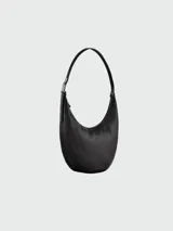 Bolso de hombro tipo hobo de la línea Roseau Essential de Longchamp, confeccionado en cuero vacuno con textura granulada. Presenta una silueta curva, cierre superior con cremallera y el distintivo cierre de bambú metálico de la marca en el lateral.