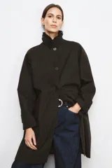 Trench oversize color negro de la colección Zara Woman, confeccionado en hilatura con mezcla de algodón. Presenta cuello solapa, manga larga ajustable con trabillas, bolsillos delanteros y cierre frontal con botones.