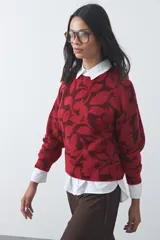 Sweater de punto con diseño estampado de hojas en tonos azul claro y azul oscuro. Presenta cuello redondo, mangas largas y terminaciones acanaladas en puños y ruedo.
