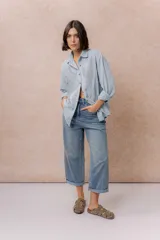 Pantalón de jean de tiro alto, corte culotte y pierna ancha, color azul medio con lavado desgastado.