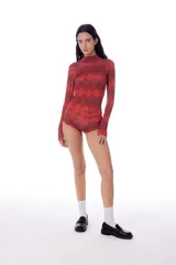 Polera de tela elastizada con cuello alto y estampado de rombos rojos y negros.