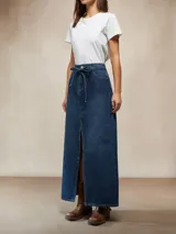 Falda larga de denim color azul oscuro, de corte recto y con abertura frontal pronunciada. Presenta un tiro alto con ajuste de lazo en la cintura.