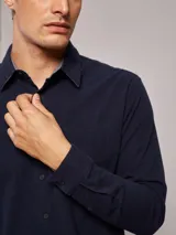 Camisa de manga larga confeccionada en tejido de franela de algodón con un toque de spandex. Presenta cuello clásico, cierre frontal con botones y un bolsillo en el pecho.