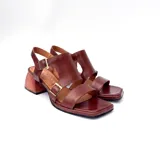 Sandalias de cuero color marrón con diseño de tiras anchas, hebillas metálicas doradas y taco ancho de madera de 4.5 cm.