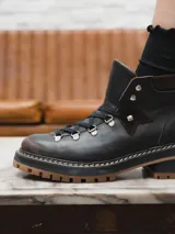 Borcego de cuero negro con cordones y suela track color caramelo.