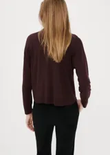 Jersey de punto bordó con cuello polo y cierre frontal de botones ocultos, de manga larga y diseño recto.